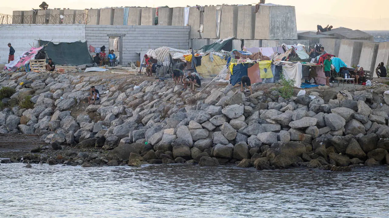 Decenas de personas viven y pernoctan en la playa del Trampol&iacute;n, a 28 de agosto de 2026, en Ceuta (Espa&ntilde;a). En la zona de la playa del Trampol&iacute;n permanecen a&uacute;n cientos de migrantes en situaci&oacute;n irregular, donde han vuelto a construir chozas.