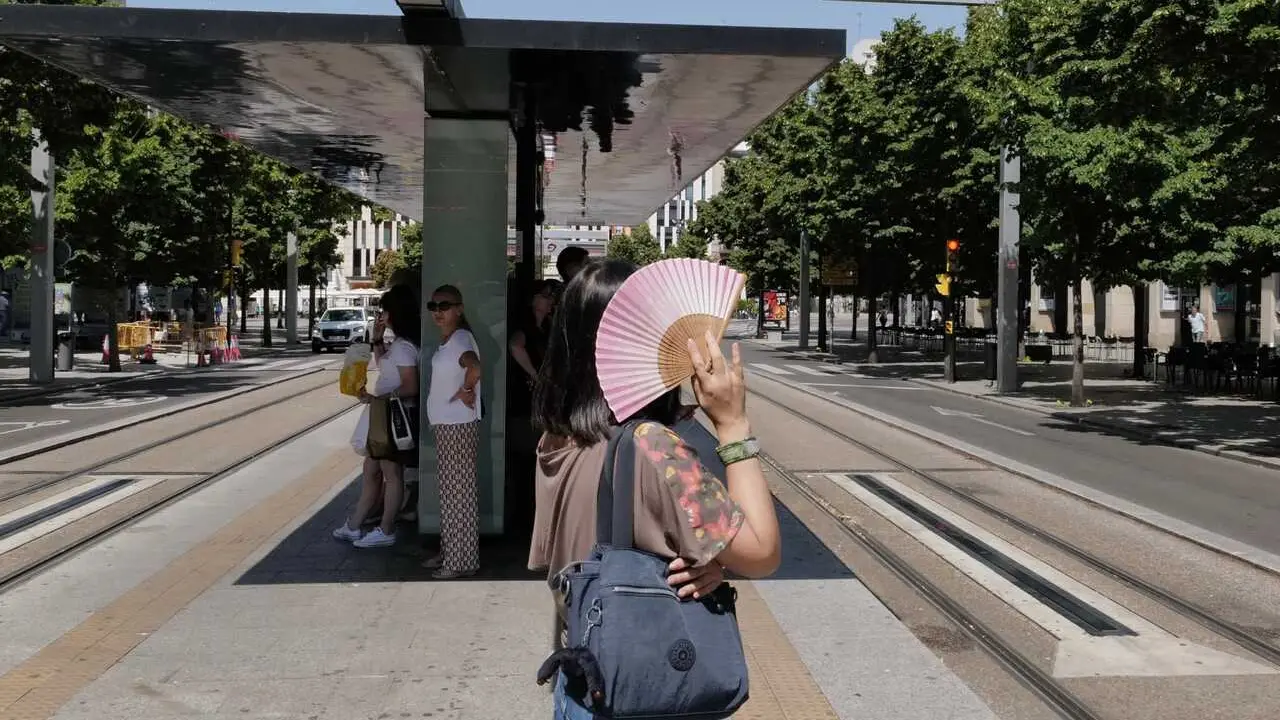 Archivo - Una mujer se tapa del sol con un abanico en la parada del tranv&iacute;a del Paseo de La Independencia, a 10 de julio de 2023, en Zaragoza, Arag&oacute;n (Espa&ntilde;a). 