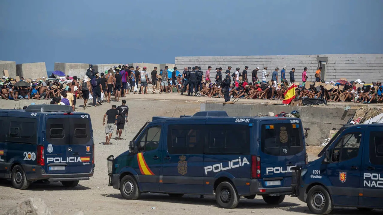 Decenas de migrantes asentados en la playa del Trampol&iacute;n, a 31 de agosto de 2026, en Ceuta (Espa&ntilde;a).