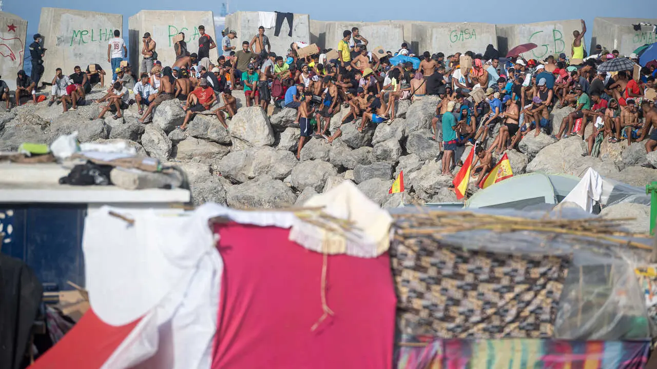 Decenas de migrantes en la playa de El Trampol&iacute;n, a 7 de septiembre de 2026, en Ceuta (Espa&ntilde;a).