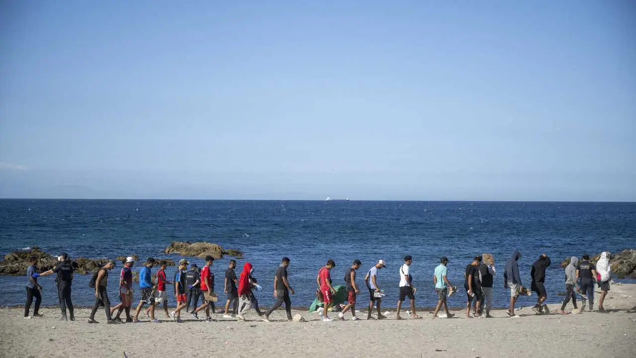 Varios inmigrantes en una playa, a 21 de agosto de 2026, en Ceuta (Espa&ntilde;a).