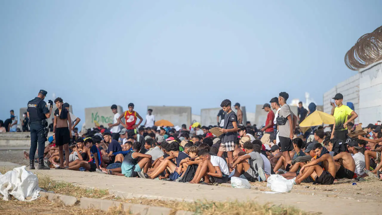 Decenas de migrantes en la playa de El Trampol&iacute;n, a 7 de septiembre de 2026, en Ceuta (Espa&ntilde;a).