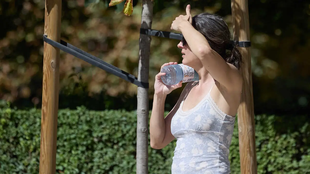 Archivo - Una mujer con una botella de agua en el parque de El Retiro durante una segunda ola de calor, a 23 de julio de 2024, en Madrid (Espa&ntilde;a).